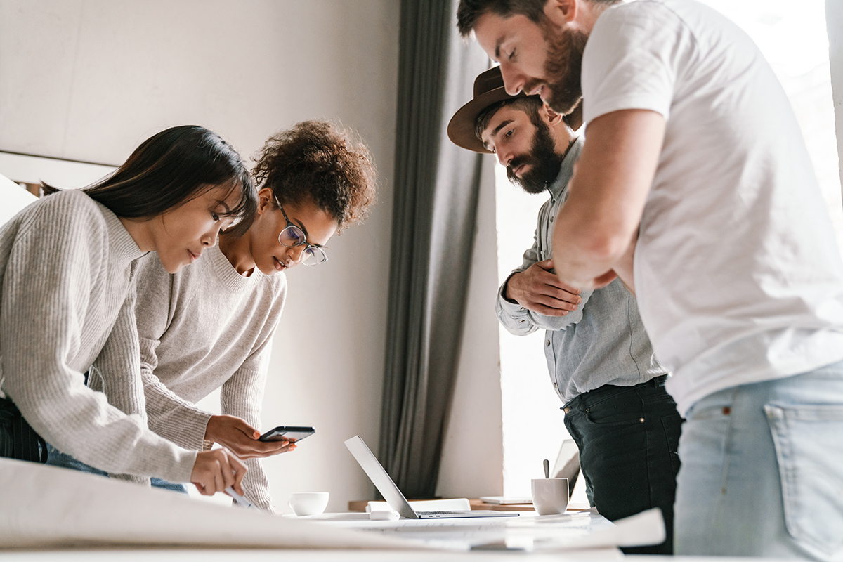 Image,Of,Multiethnic,Young,Female,And,Male,Colleagues,Discussing,Business Image of multiethnic young female and male colleagues discussing business ideas at table while working in office