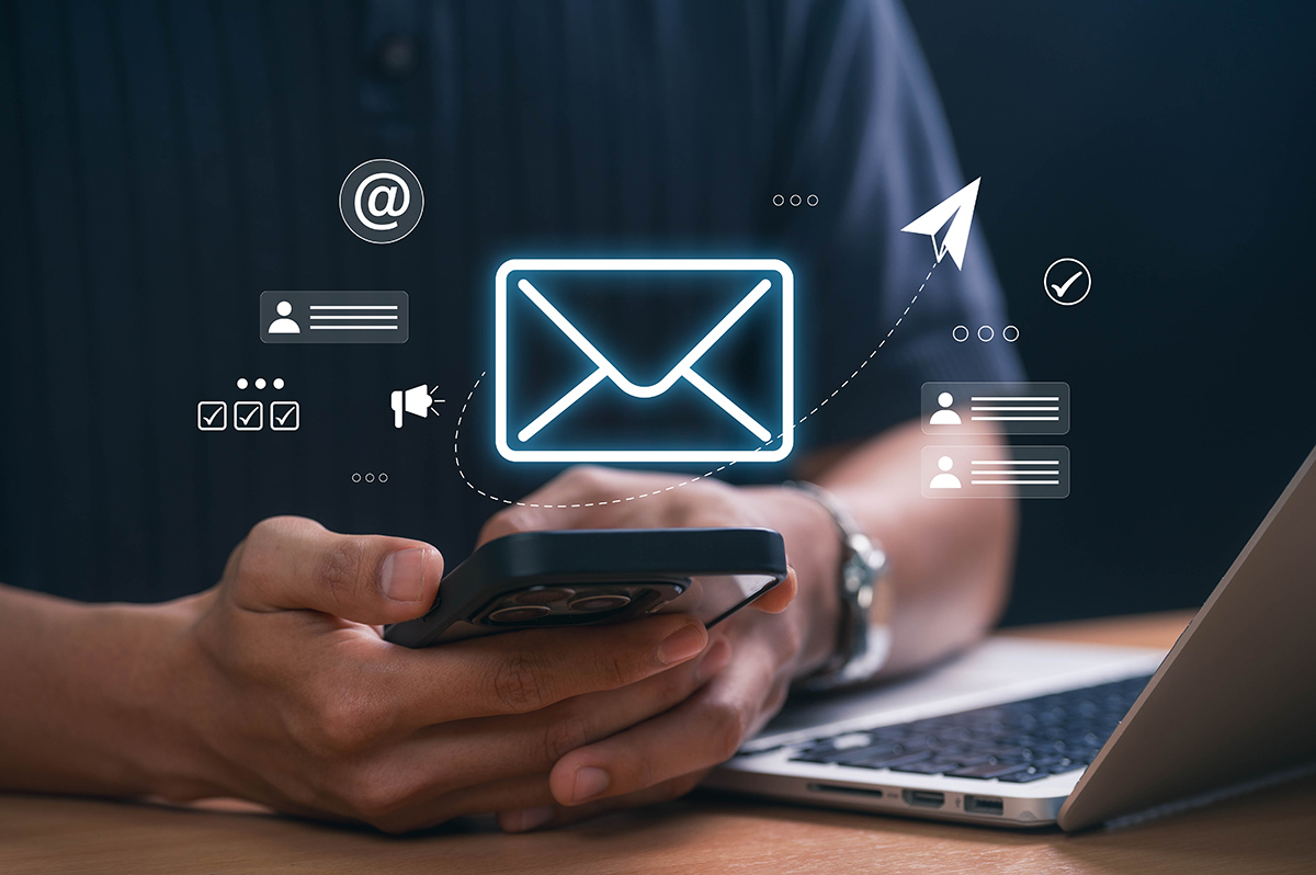 Digital,Marketer,Using,Email,Marketing,Tools,On,Laptop,And,Smartphone, Digital marketer using email marketing tools on laptop and smartphone, sending newsletters and analyzing campaign performance to engage subscribers and grow business through personalized content.